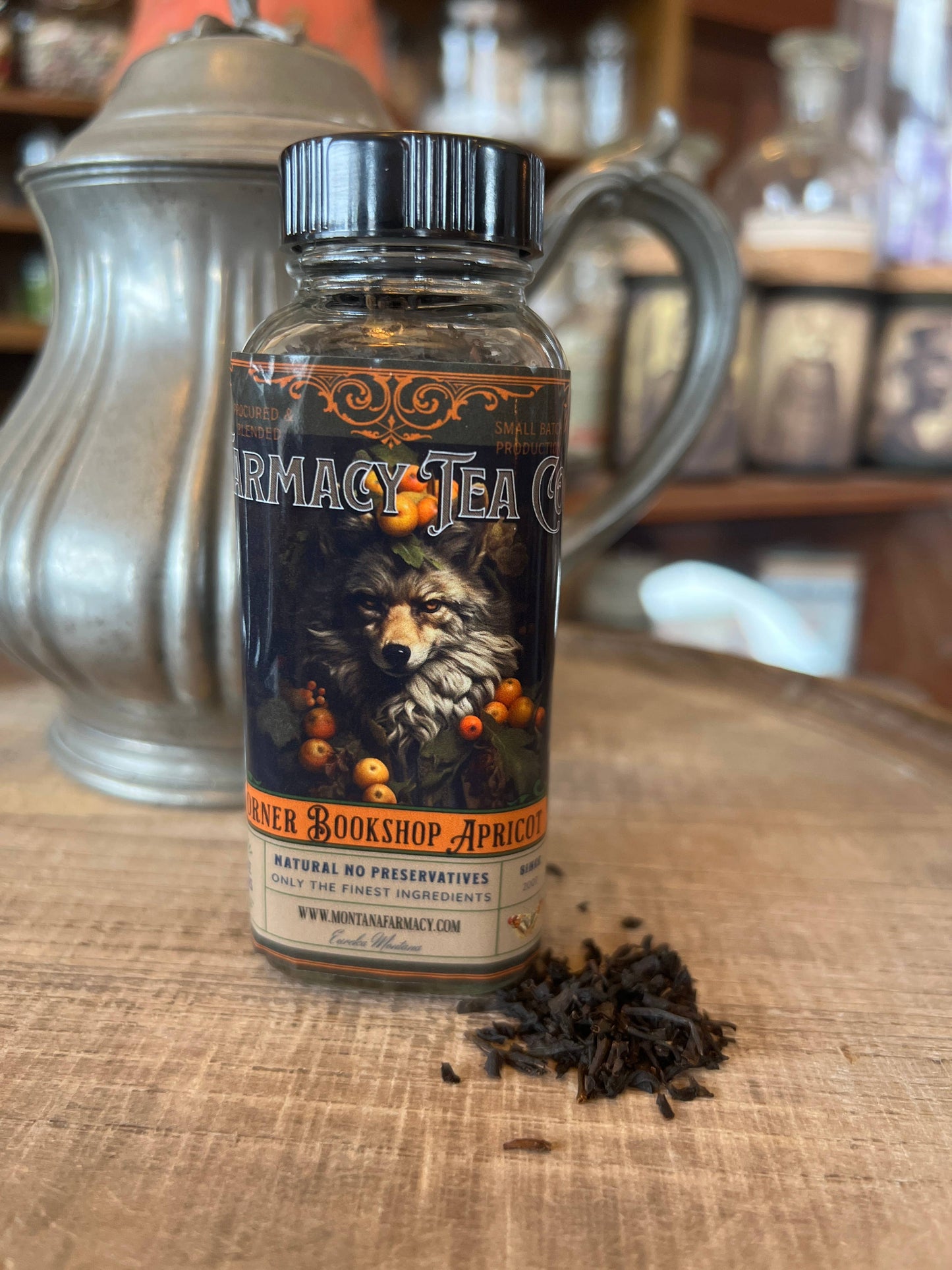 Bottle of Montana Farmacy tea on a wooden surface with a wolf illustration on the label.