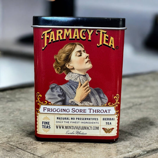 Red tin canister of Farmacy Tea with vintage-style label featuring a woman and text.