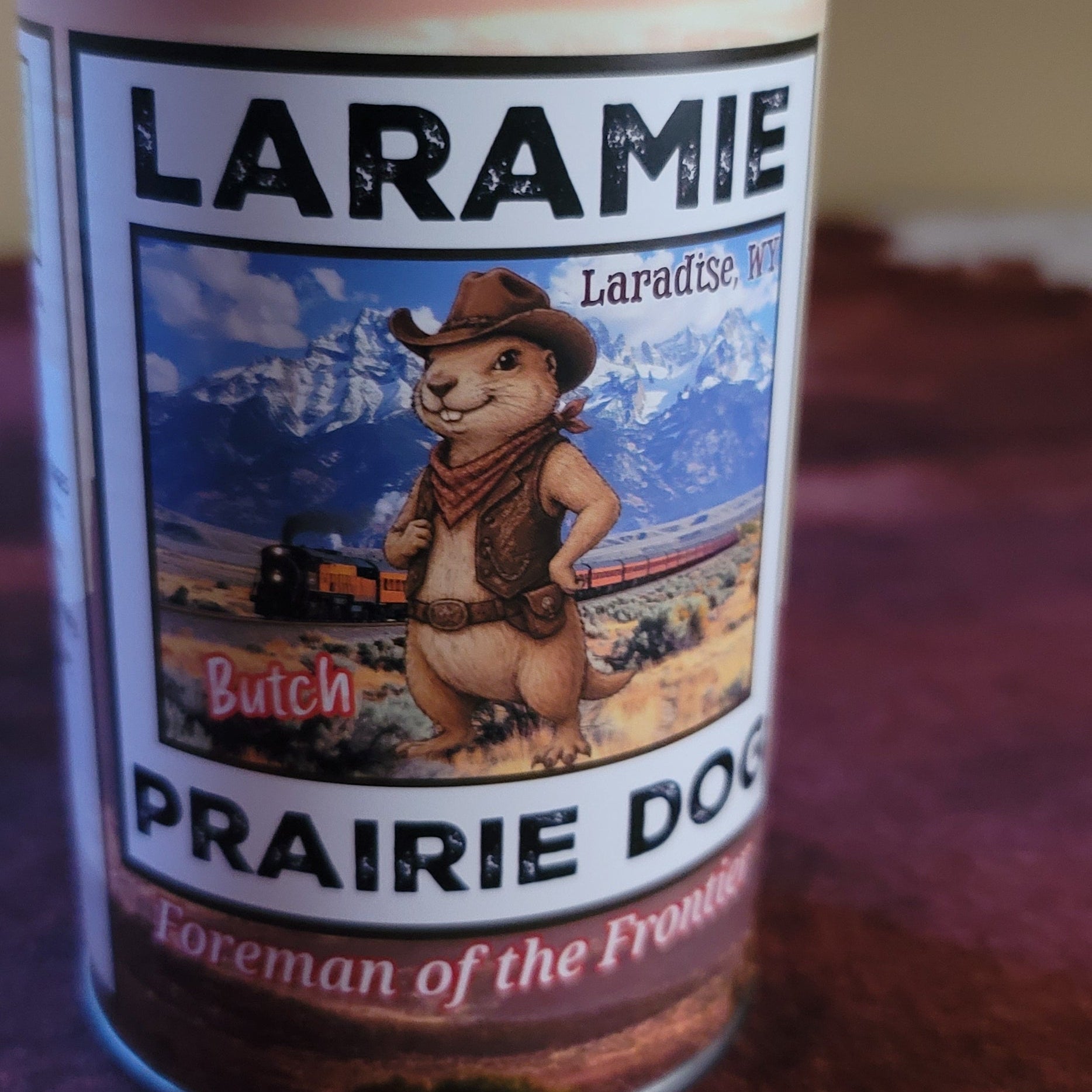 Silver colored can that says Laramie Prairie Dog on the label on a tan background