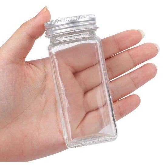 "Clear glass jar of Montana Farmacy AnxiaTEA calming herbal tea blend held in hand against white background"