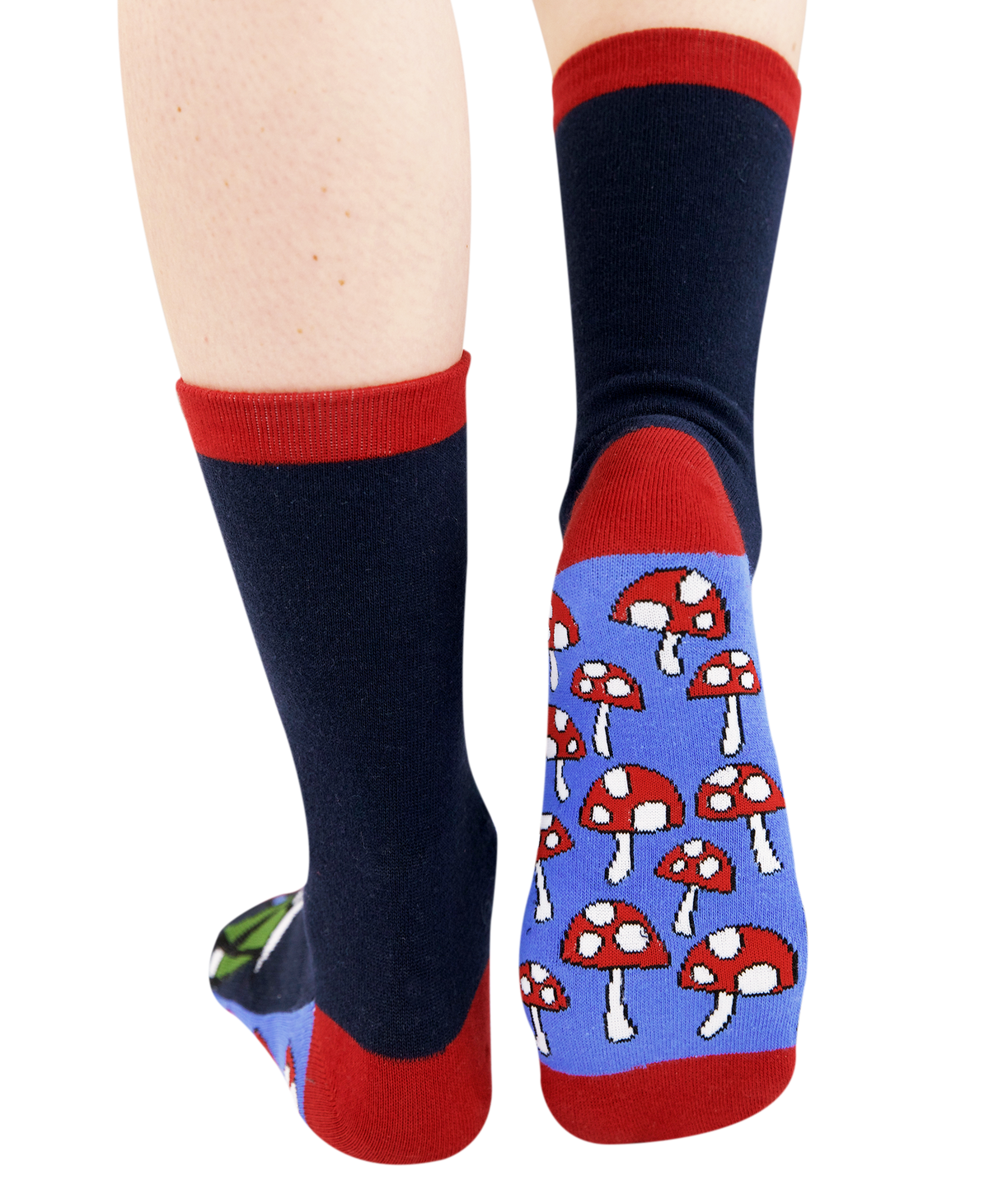 A pair of crew socks worn on lower legs, featuring a dark navy blue body, red cuffs and toes, and a light blue heel section with a red and white mushroom pattern.