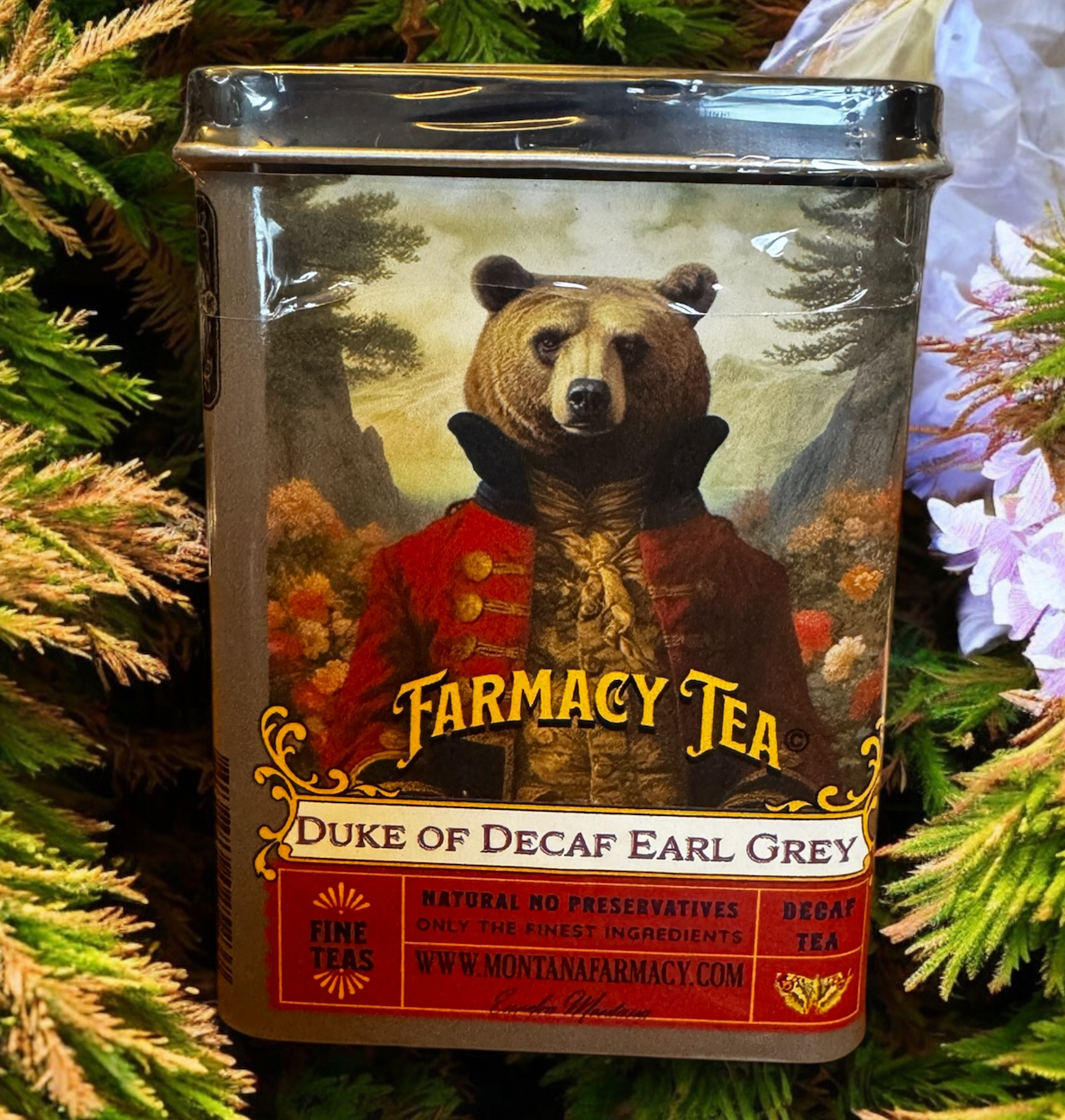Tea canister with bear illustration labeled 'Farmacy Tea Duke of Decaf Earl Grey' on a green leafy background.