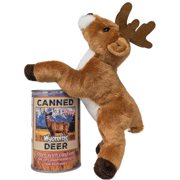 A plush toy deer standing on its back hooves against a can labeled "Canned Wyoming Deer" on a plain white background. The toy has brown fur, a white chest and muzzle, dark brown antlers, and dark brown hooves.
