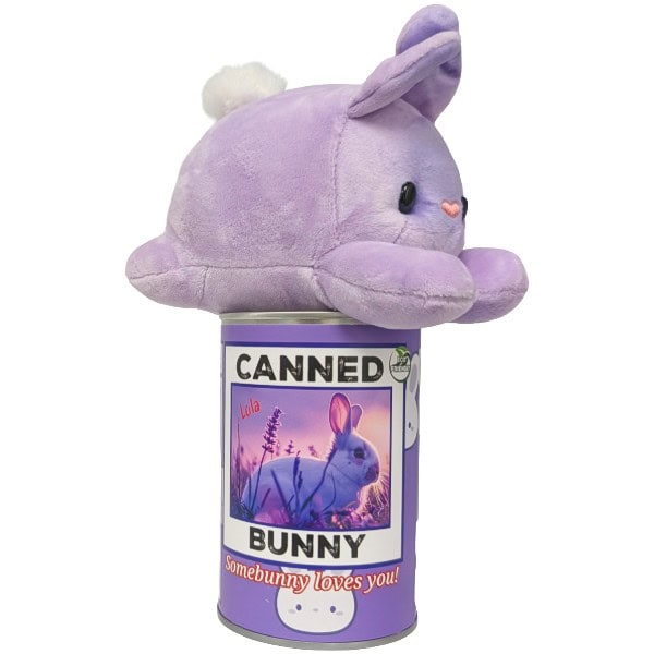 A purple plush bunny toy with a small white pom-pom on tail, perched on top of a purple cylindrical can labeled 'CANNED BUNNY' with a bunny photo and the phrase 'somebunny loves you!'.