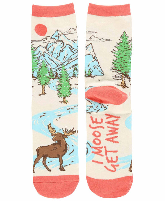 A pair of crew socks with a colorful outdoor landscape print featuring mountains, pine trees, a moose, and a red sun, with the text 'I MOOSE GET AWAY' on one sock.