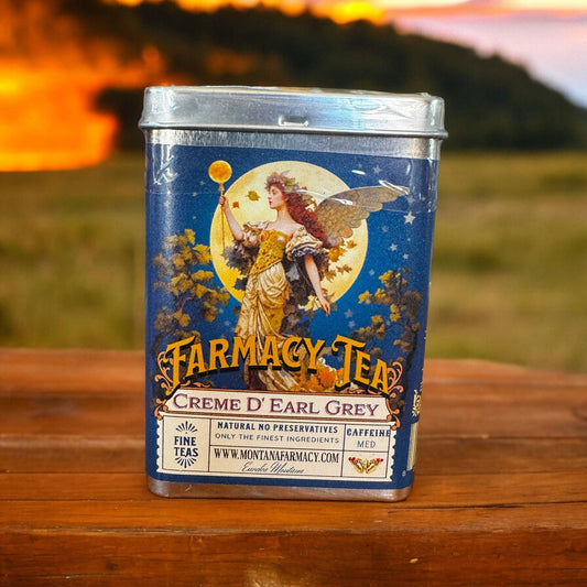 Montana Farmacy Tea Tin with an Angel on the label and  blurry view of nature in the background
