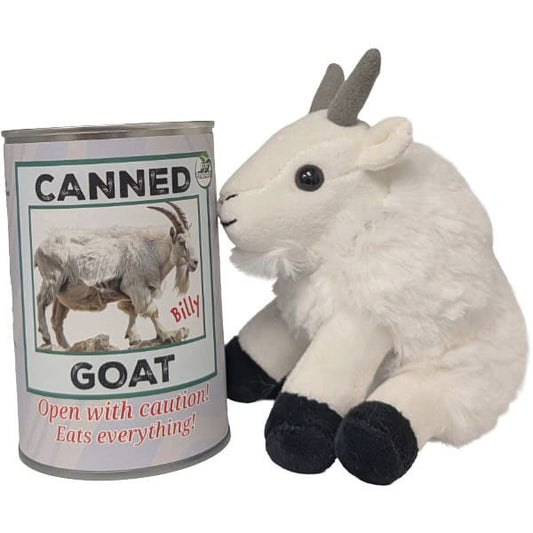 A plush white goat toy with gray horns and black hooves sits beside a novelty can labeled 'CANNED GOAT' with the text 'Open with caution! Eats everything!' on a plain white background.