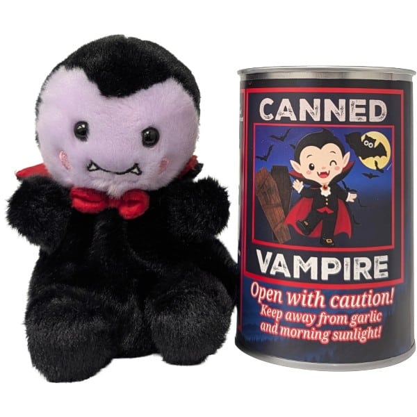 A plush vampire toy with black fur, a pale face, and a red bow tie sits next to a novelty can labeled 'CANNED VAMPIRE' on a plain white background