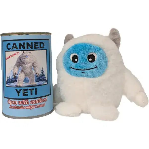 A white plush yeti toy with a blue face sits next to a matching blue 'Canned Yeti' can on a plain white background.
